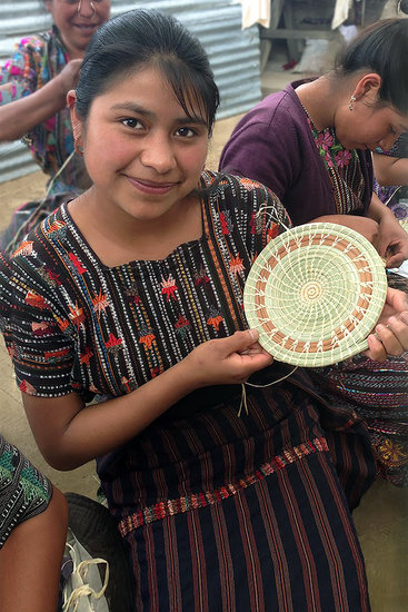 A Mayan Hands basket maker displays her work.