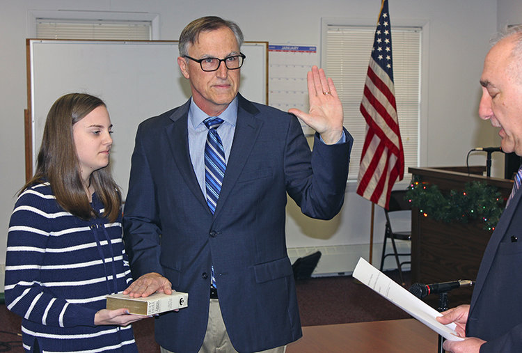 Mary Hennessy holds a Bible as her father, William, takes the oath of office