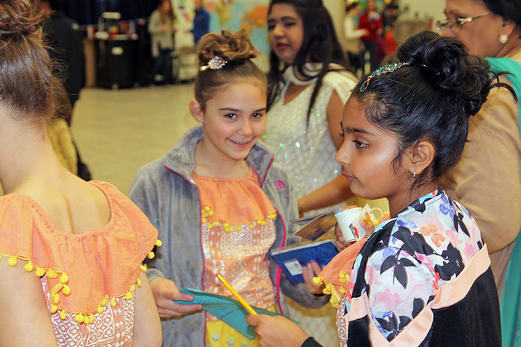Leah Michaelides, left, and Sharanya Iyer were dressed in identical colorful Indian dresses as they prepared for their dance performance. 