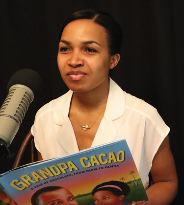 Elizabeth Zunon holding her book, Grandpa Cacao