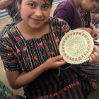 A Mayan Hands basket maker displays her work.