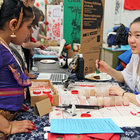 Ruby Yuan, right, prepares to write in Chinese calligraphy the names of students taking part in the first-ever International Night at Lynnwood Elementary School on April 12.